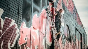 Graffiti sprayer on ladder