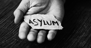 Asylum seeker holding note saying Asylum