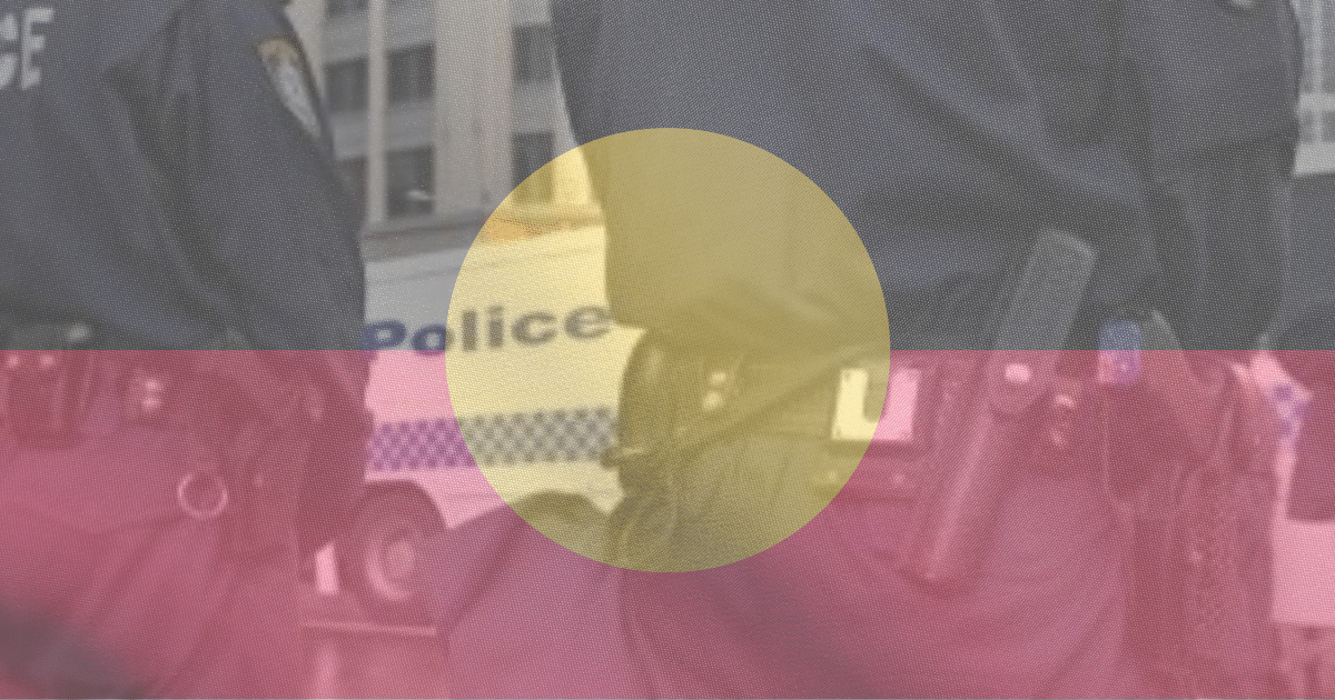 Aboriginal flag with police officers in the background