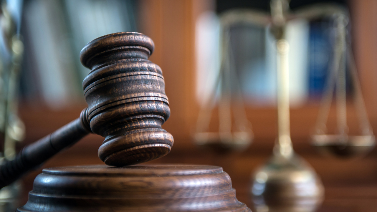 a gavel in a courtroom beside scales of justice
