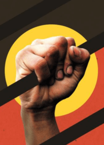 Indigenous hand grips jail bar with backdrop of Aboriginal flag