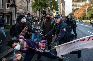 Police tackling protestor, protestor falling to the ground