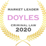 A badge featuring golden laurel leaves in a circular arrangement. Inside the circle are the words "MARKET LEADER DOYLES CRIMINAL LAW 2020" with "DOYLES" highlighted in a larger pink font.
