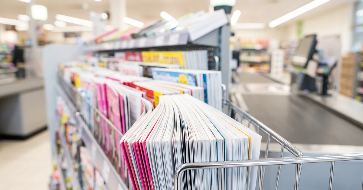 Supermarket checkout magazine rack filled with glossy weekly magazines