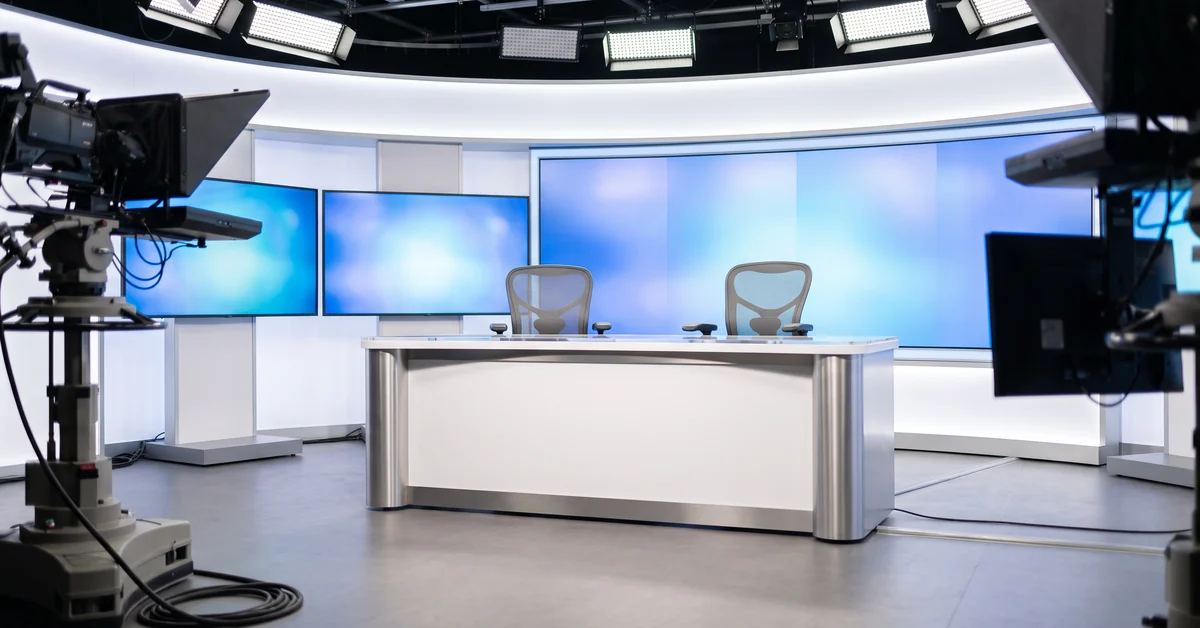 Empty Australian television news studio with an unbranded desk and blank backdrop screens
