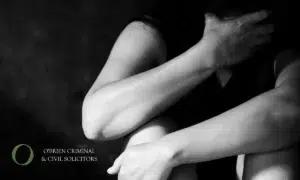 a black and white photo of a woman's arms covering her face