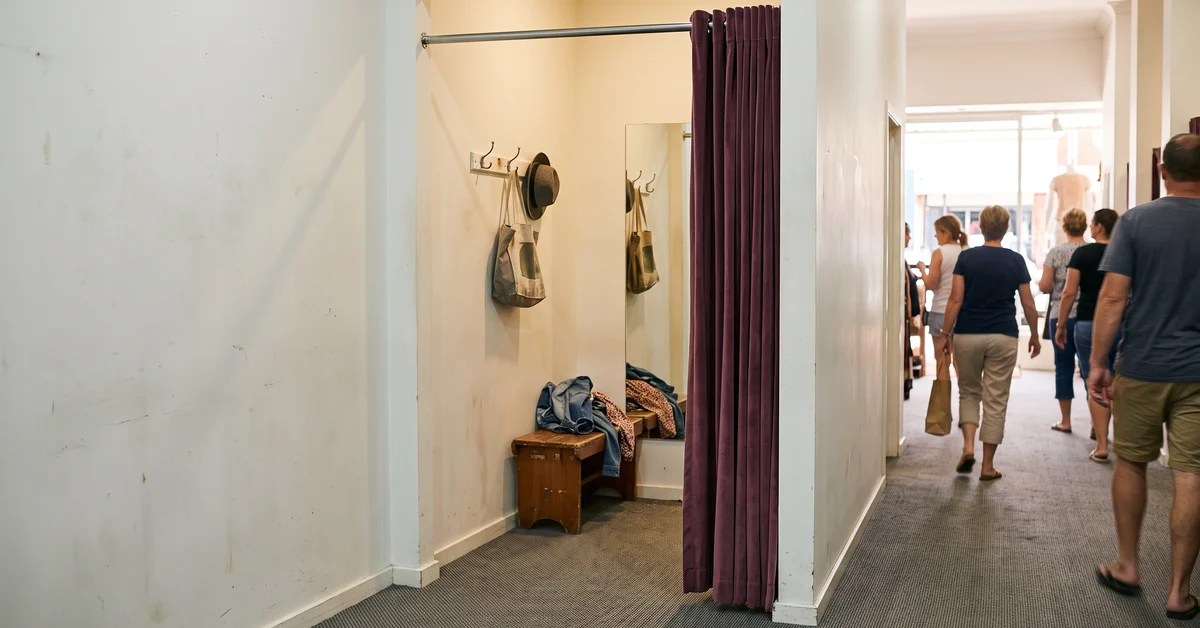Empty fitting room with the curtain drawn back