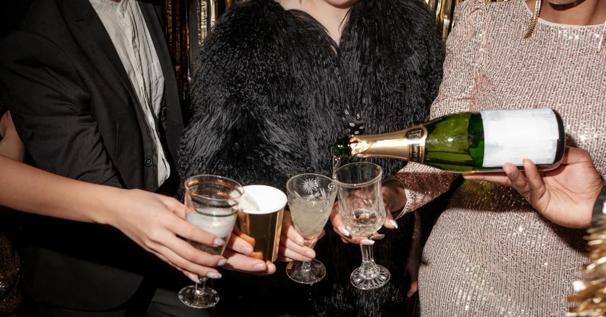 new years eve party with a group of friends pouring champagne into a glass
