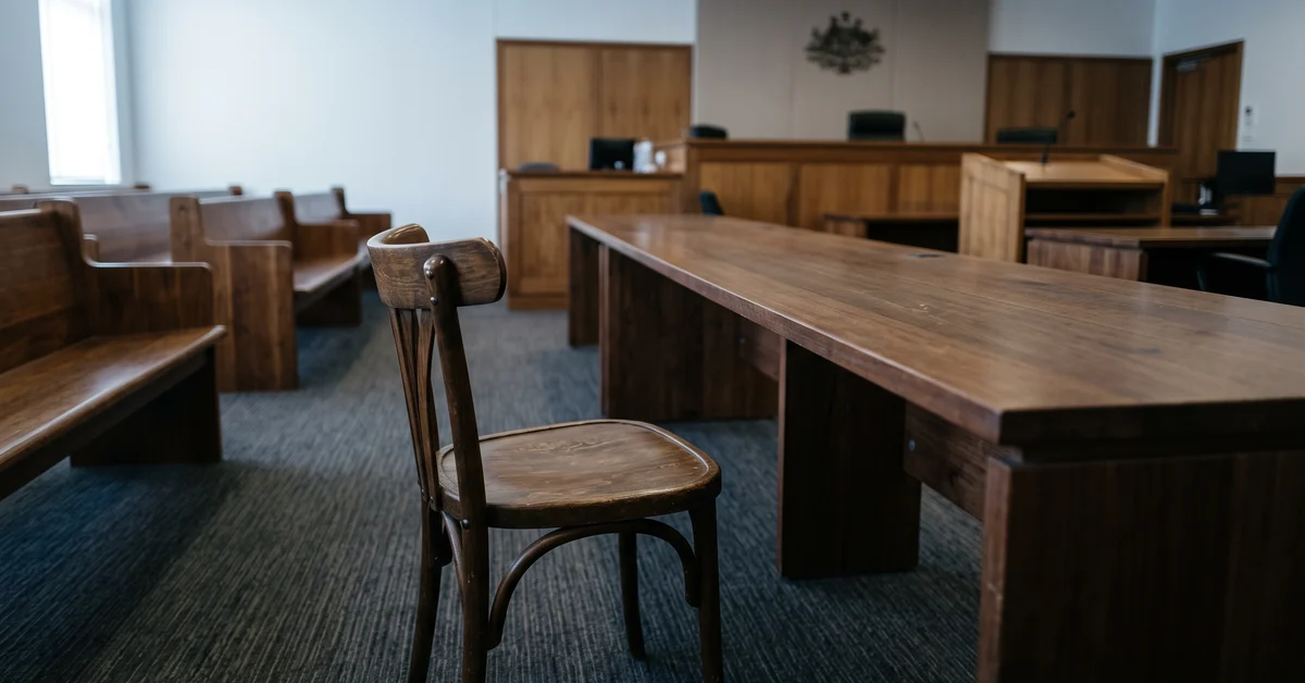 Single empty chair at the bar table of an otherwise empty courtroom