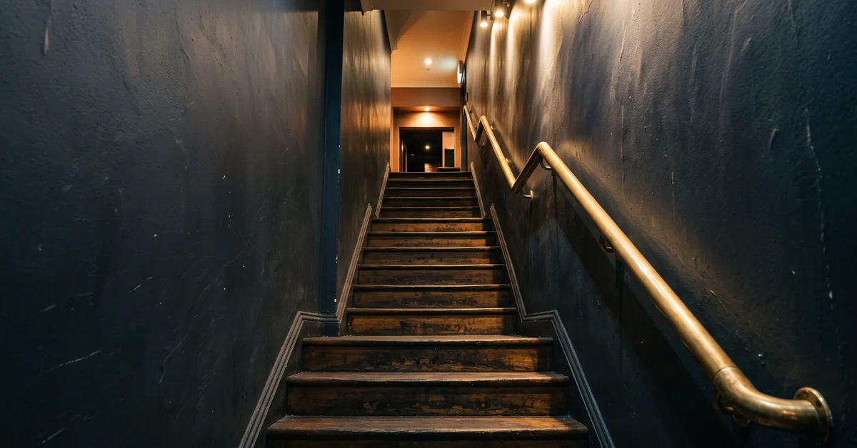 Narrow stairwell leading up to a city nightclub at night