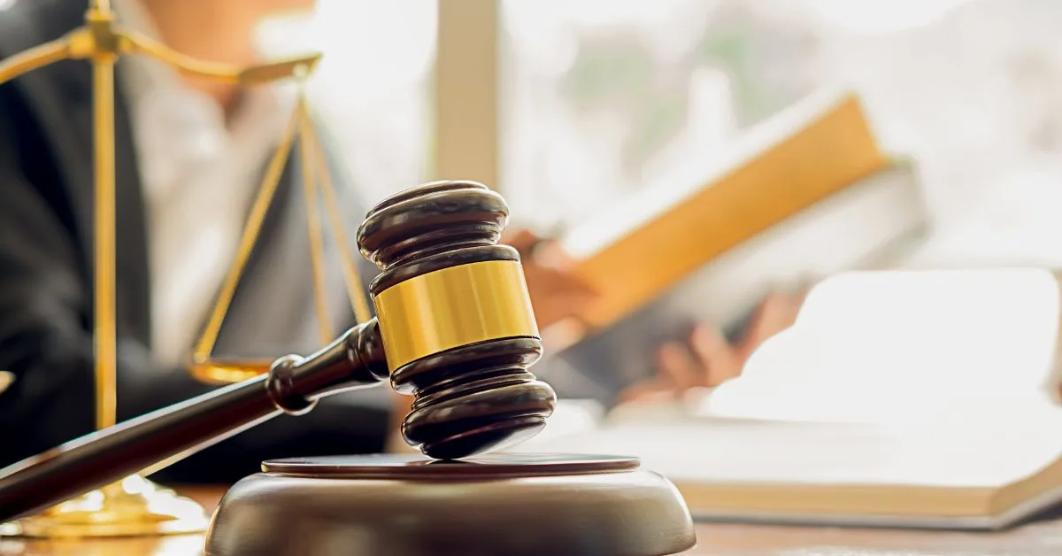 a court gavel with a legal textbook in the background