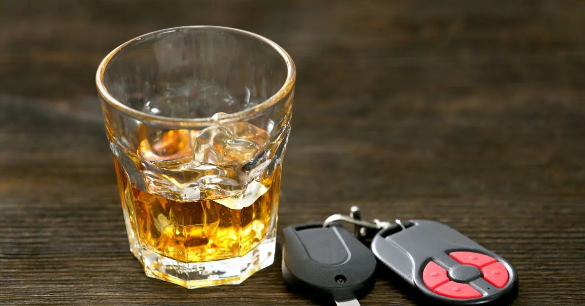 a glass of whiskey with car keys