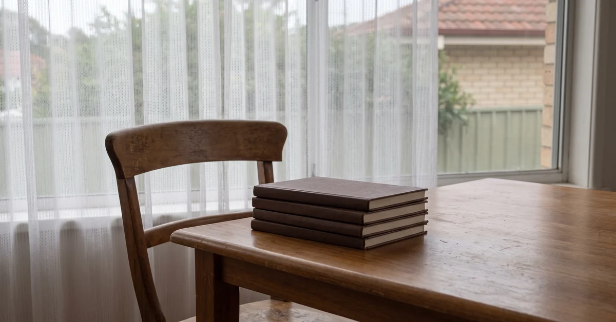 Empty chair at a dining table with closed schoolbooks