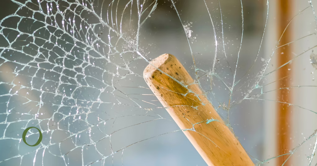 a baseball bat smashing a glass window
