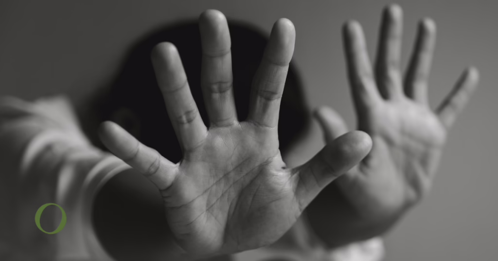a black and white photo of a girl covering her head with her hands