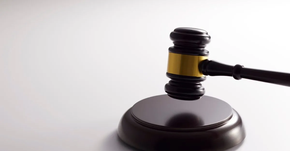 Judge's gavel resting on a round wooden sound block, symbolizing a legal decision or ruling