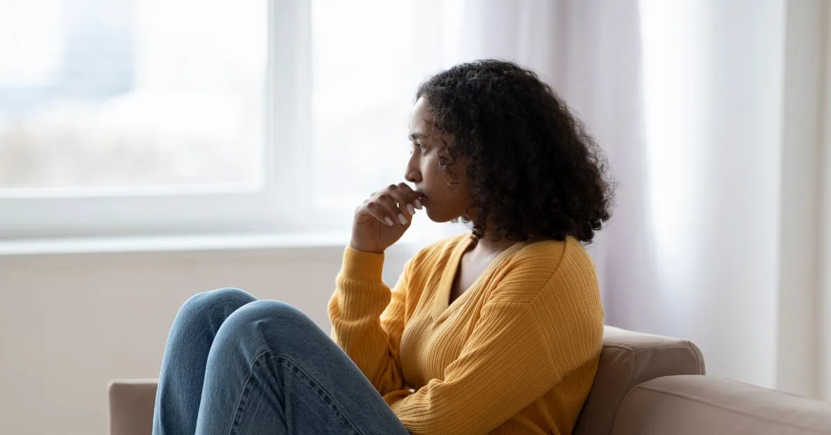 a woman sitting on the sofa looking distressed