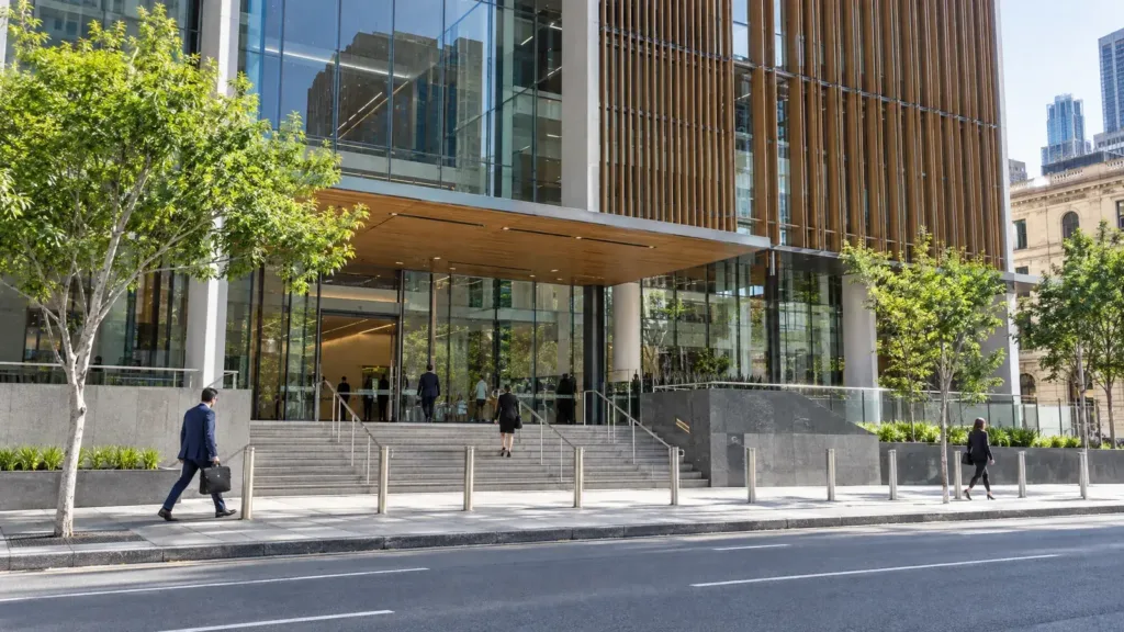 Lawyers in business attire walking toward the entrance of a modern glass and timber courthouse building in Brisbane